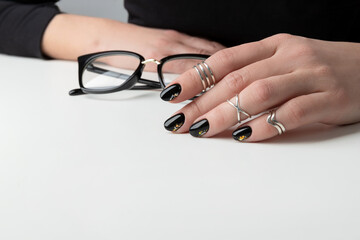 Wall Mural - Beautiful womans hand with elegant manicure. Minimal black nail design