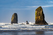 The Needles on Canon Beach in a rough sea with white capped waves and blue sky and clouds, Canon Beach, Oregon