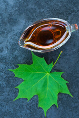 maple syrup and maple leaf on a black background. top view.
