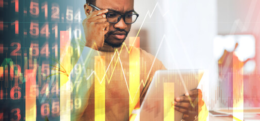Poster - Serious African american businessman working with tablet computer at office, collage with economic info on screen
