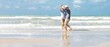 Happy  asian senior couple  dancing  on beach with blue sky background
