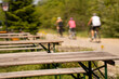 © FranciscoJavier - picnic tables beside a bicycle path with ciclists in the background