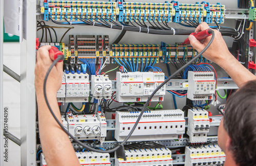 Fotomural Ein Elektriker misst die Spannung in einer elektrischen Anlage