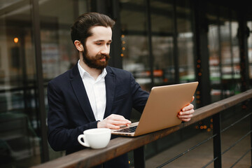 Wall Mural - Handsome man in a black suit. Businessman working in a office