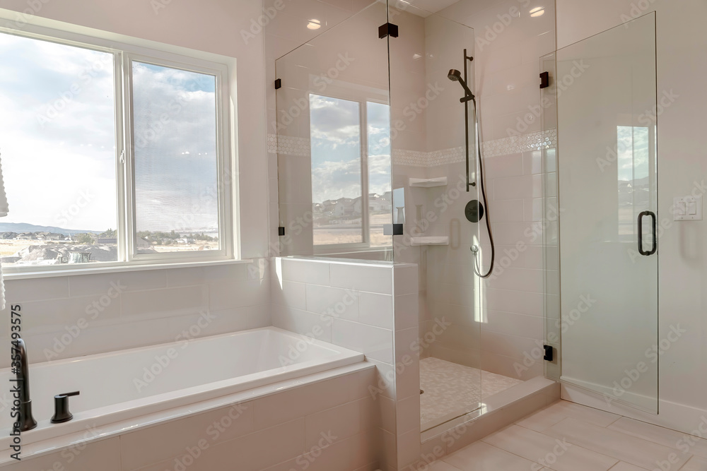 Built in bathtub with black faucet and shower stall with half glass enclosure - obrazy, fototapety, plakaty 