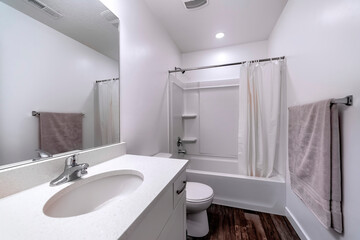 Clean white bathroom interior with oval sink mirror toilet bathtub and shower