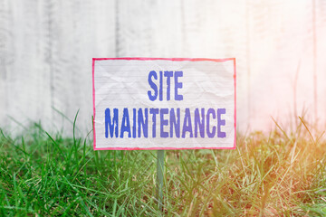 Fototapete - Text sign showing Site Maintenance. Business photo text Monitoring and regularly checking your website for issues Crumpled paper attached to a stick and placed in the green grassy land