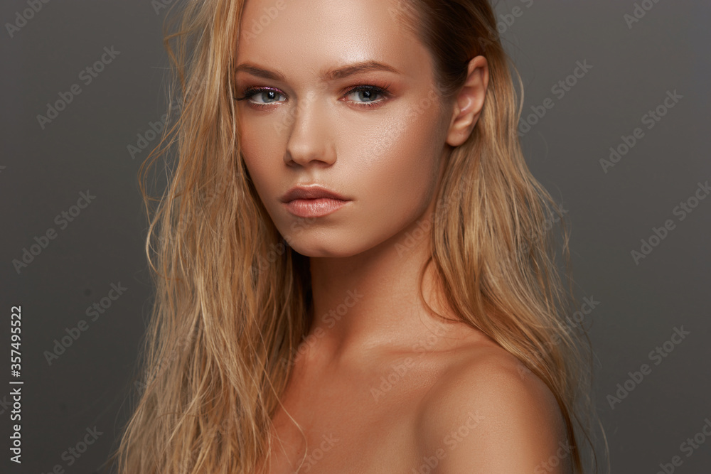 Closeup face fashion beauty portrait of young beautiful caucasian blonde woman with wet hair and makeup posing against gray background. - obrazy, fototapety, plakaty 