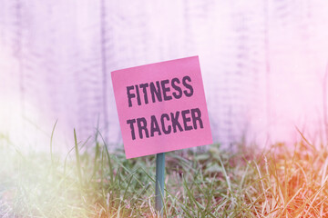 Poster - Writing note showing Fitness Tracker. Business concept for a monitoring device that records any healthrelated activity Plain paper attached to stick and placed in the grassy land