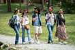 © pressmaster - Group of young multi-ethnic friends walking path together and talking while enjoying weekends at festival campsite