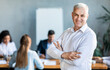 © Prostock-studio - Businessman Standing Crossing Hands In Front Of Employees In Office