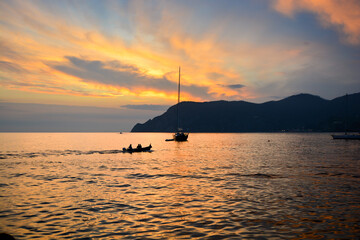 Two boats along the Ligurian coast of Vernazza harbor at sunset along the Cinque Terre, Italy