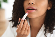 Daily Makeup. Unrecognizable Black Woman In Bathrobe Applying Pink Lipstick On Lips