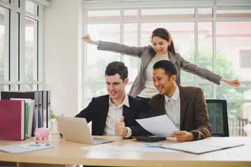 Businessmen are looking at the business plan and business results from the notebook in the office.