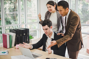 Businessmen are looking at the business plan and business results from the notebook in the office.