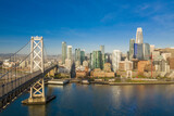 Fototapeta  - Aerial view of the San Francisco, California, skyline at sunrise. Ample copy space in blue sky. Bay bridge in foreground.