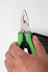 knife multitool turned into pliers in the hands of a man