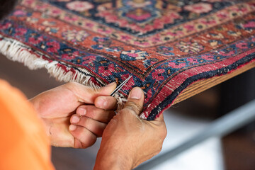 traditional hand sewing fixing with clippers old vintage antique persian carpet up close