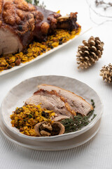 roasted pork shoulder ham slices with nuts on a white dish and food on background