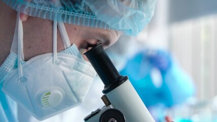Wall Mural - scientist or researcher in laboratory looking into microscope