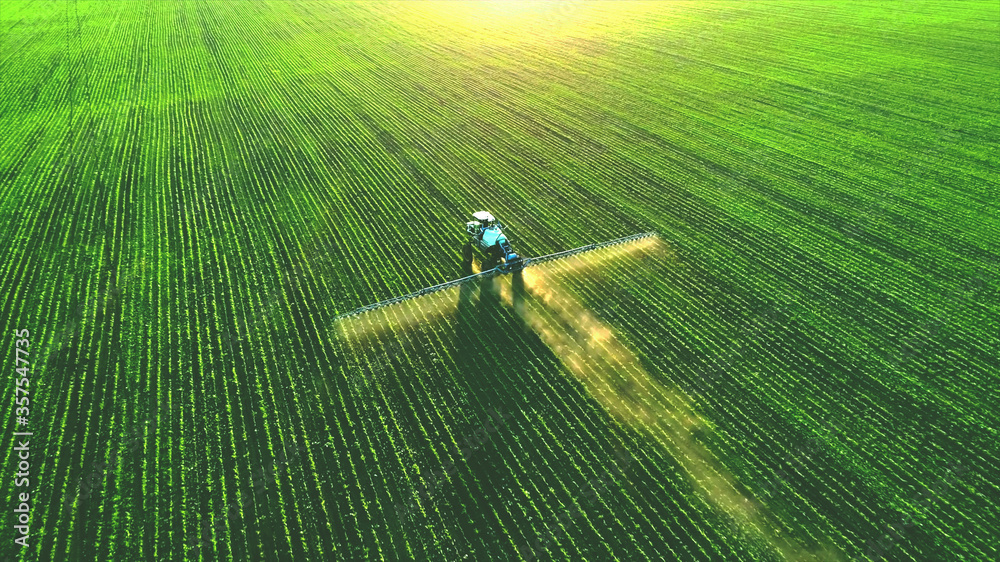 Tractor spray fertilizer on green field drone high angle view, agriculture background concept. - obrazy, fototapety, plakaty 