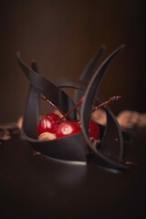 Poster - Vertical closeup shot of a chocolate cake with cherries on top