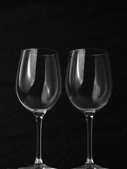 Sticker - Vertical shot of two empty wine glasses on black background