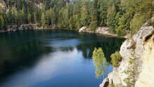 A mountain lake surrounded by forest and rocks in The Adršpach-Teplice Rocks, Bohemia, Czech Republic
