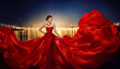 © inarik - Fashion Model in Fluttering Dress in Night City Street Lights, Elegant Woman in Red Long Gown, full length beauty portrait