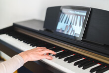 Caucasian Woman Learning To Play Piano With Video Lessons. Concept Of Virtual Learning