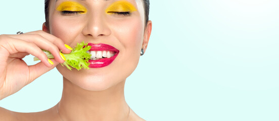 Healthy eating, diet. Beautiful healthy girl eating raw vegan food and smiling. Beauty young fashion woman eats green fresh lettuce salad leaf, organic vegetables. Vegetarian concept. Makeup and nails