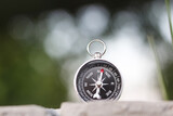 Fototapeta Mapy - round compass on natural background as symbol of tourism with compass, travel with compass and outdoor activities with compass