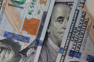 Benjamin Franklin peeking through 100 dollar banknotes