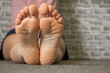© Виктория Котлярчук - young girl sitting on the floor at home closeup, bottom view