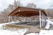 Pavilion With Wooden Arches On The Ceiling Amid Park Covered With Snow In Winter