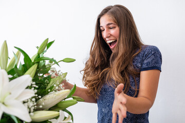 Surprised and happy Caucasian young girl receiving bouquet of flowers. Surprise Valentine's or anniversary gift