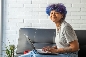 young african american woman using laptop on sofa at home