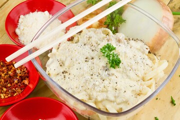 Poster - Bowl of spaghetti with parmesan on top and some garnishes in red plates nearby