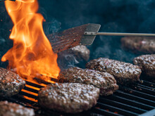 Burgers Cooking On An Open Flame Grill Top