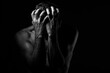© Aleksandr - Man covers his face with his hands. Regret or fear. On a dark background. Black and white photography.
