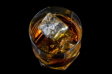 Sticker - Glass of whiskey with cube ice on black background