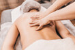 © andrey gonchar - Close-up of the masseur hands kneading the longitudinal muscles of the back along the spine