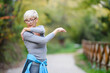 © lordn - Elderly woman exercising outdoors in nature having shoulder pain