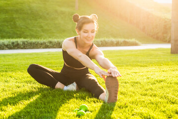 woman do yoga in the park and smiles. outdoor sports. healthy sport lifestyle. fitness, yoga, stretching. breathes fresh, clean summer air, no virus. slender girl in a sports uniform.