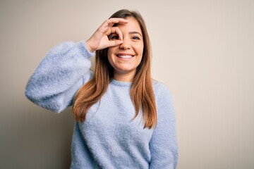 Sticker - Beautiful young woman wearing casual winter sweater standing over isolated background doing ok gesture with hand smiling, eye looking through fingers with happy face.