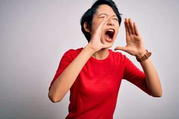 Poster - Young beautiful asian girl wearing casual red t-shirt standing over isolated white background Shouting angry out loud with hands over mouth