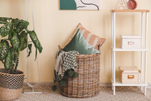 Basket With Pillows And Plaid In Room