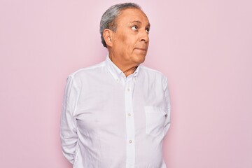 Poster - Senior handsome grey-haired man wearing elegant shirt over isolated pink background smiling looking to the side and staring away thinking.