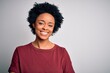 © Krakenimages.com - Young beautiful African American afro woman with curly hair wearing casual t-shirt standing happy face smiling with crossed arms looking at the camera. Positive person.