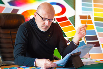 Poster - designer chooses a color. adult man on the background of a palette with flowers. concept - a man wor